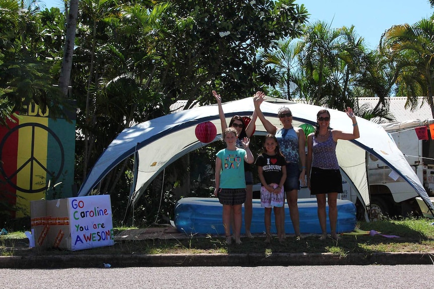 people in a front yard with a blow up pool