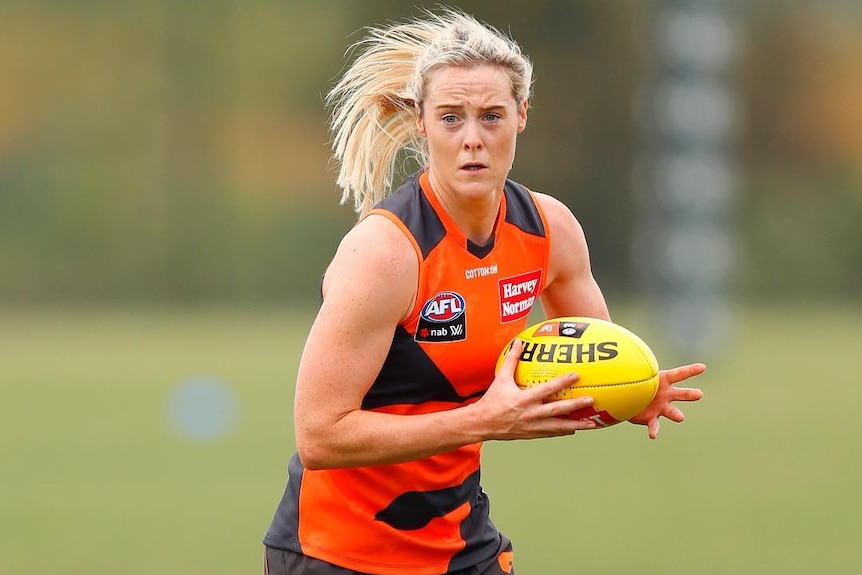 Yvonne Bonner holds a yellow Australian rules ball while training with the GWS Giants.