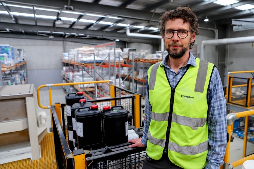 A man stands in a warehouse.