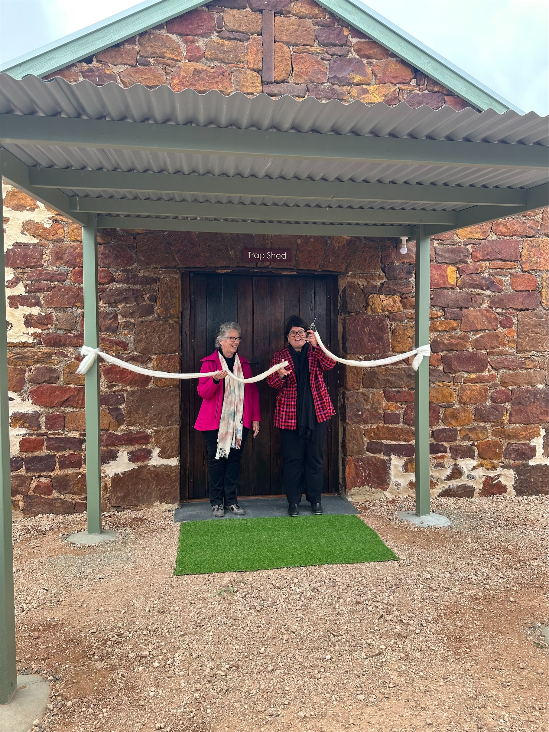 Two women cutting a ribbon 