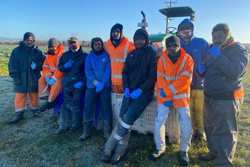Group of Islanders pose for a photo in frosty field