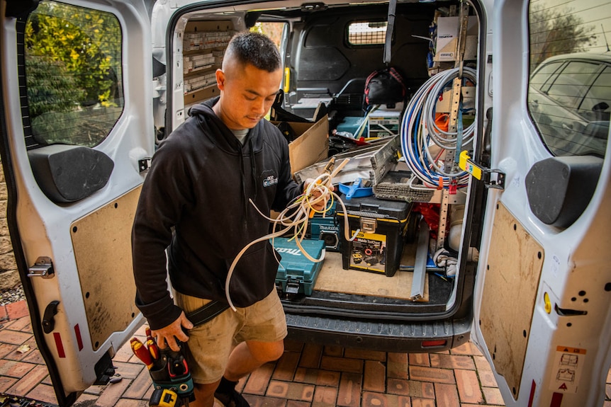 A man working out of the back of a van