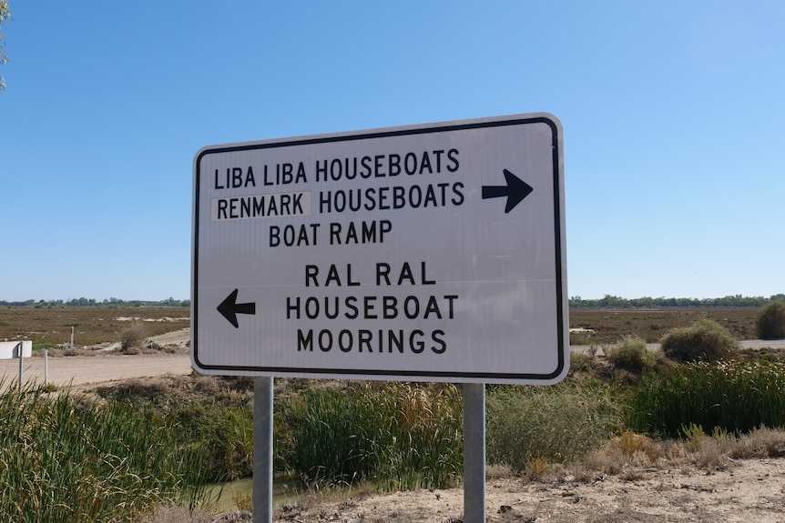 A sign that has the text 'liba liba houseboats this way, and ral ral houseboats that way'.