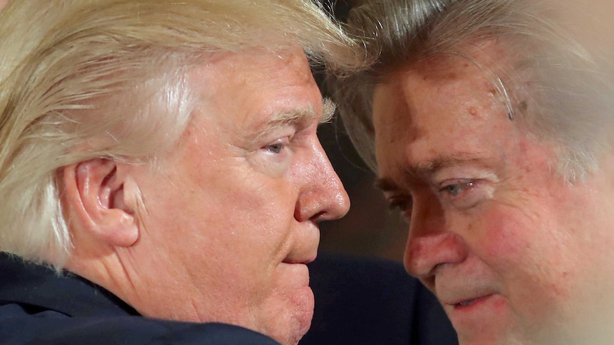 Donald Trump talks to Steve Bannon during a swearing in ceremony at the White House on January 22, 2017.