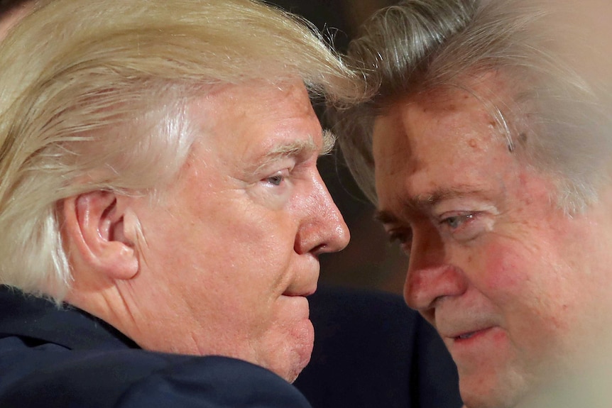 Donald Trump talks to Steve Bannon during a swearing in ceremony at the White House on January 22, 2017.