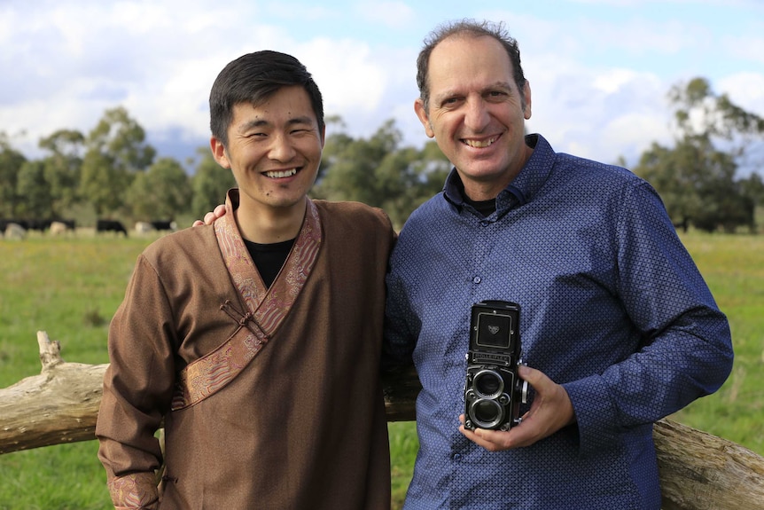 Photographers Davaanyam Delgerjargal (Left) and Jerry Galea (right) smile for a photo, while on a farm in Australia.
