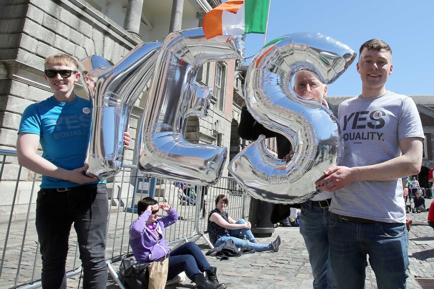 Supporters for same-sex marriage hold an inflatable Yes sign as they wait for the announcement on the referendum in Dublin castle