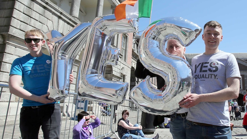 Supporters for same-sex marriage hold an inflatable Yes sign as they wait for the announcement on the referendum in Dublin castle