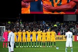 Saudi Arabian players are seen milling about during the minute's silence