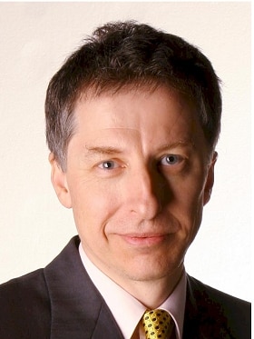 A portrait shot of a man wearing a suit.