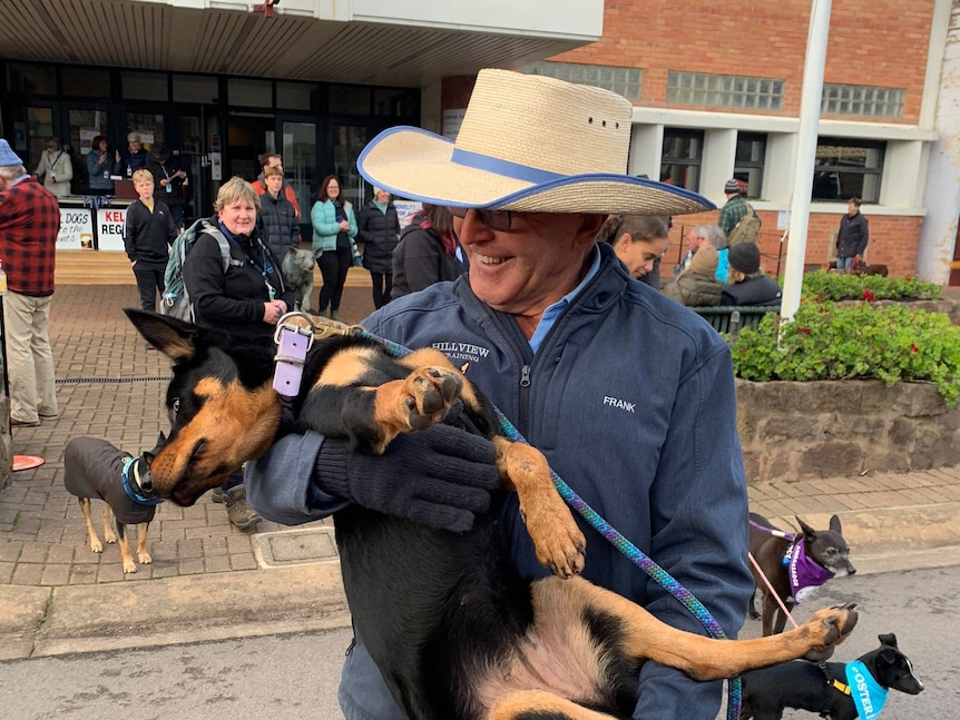 Frank Finger smiles as he holds his kelpie Annie in his arms