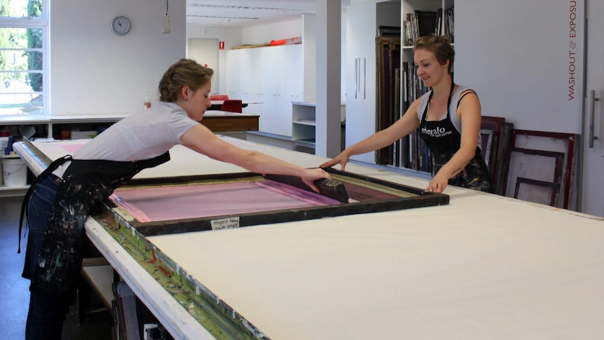 Public programs manager Megan Hinton and screen print studio manager Jemima Parker work on a 35 metre long screen print at Megalo Print Studio and Gallery, Canberra, November 2015.