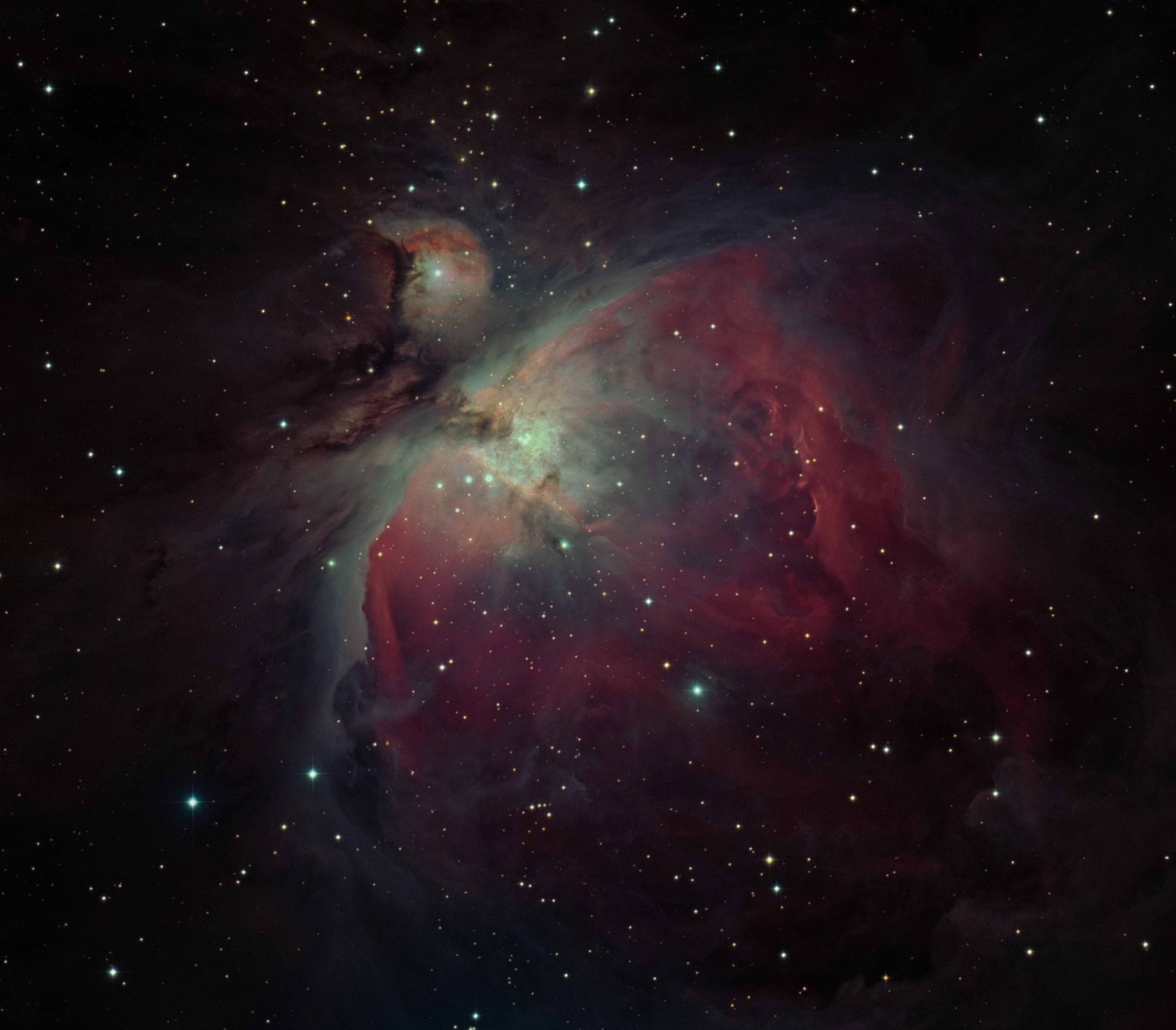 The Orion Nebula, a giant cloud of gas and dust coloured pink and green