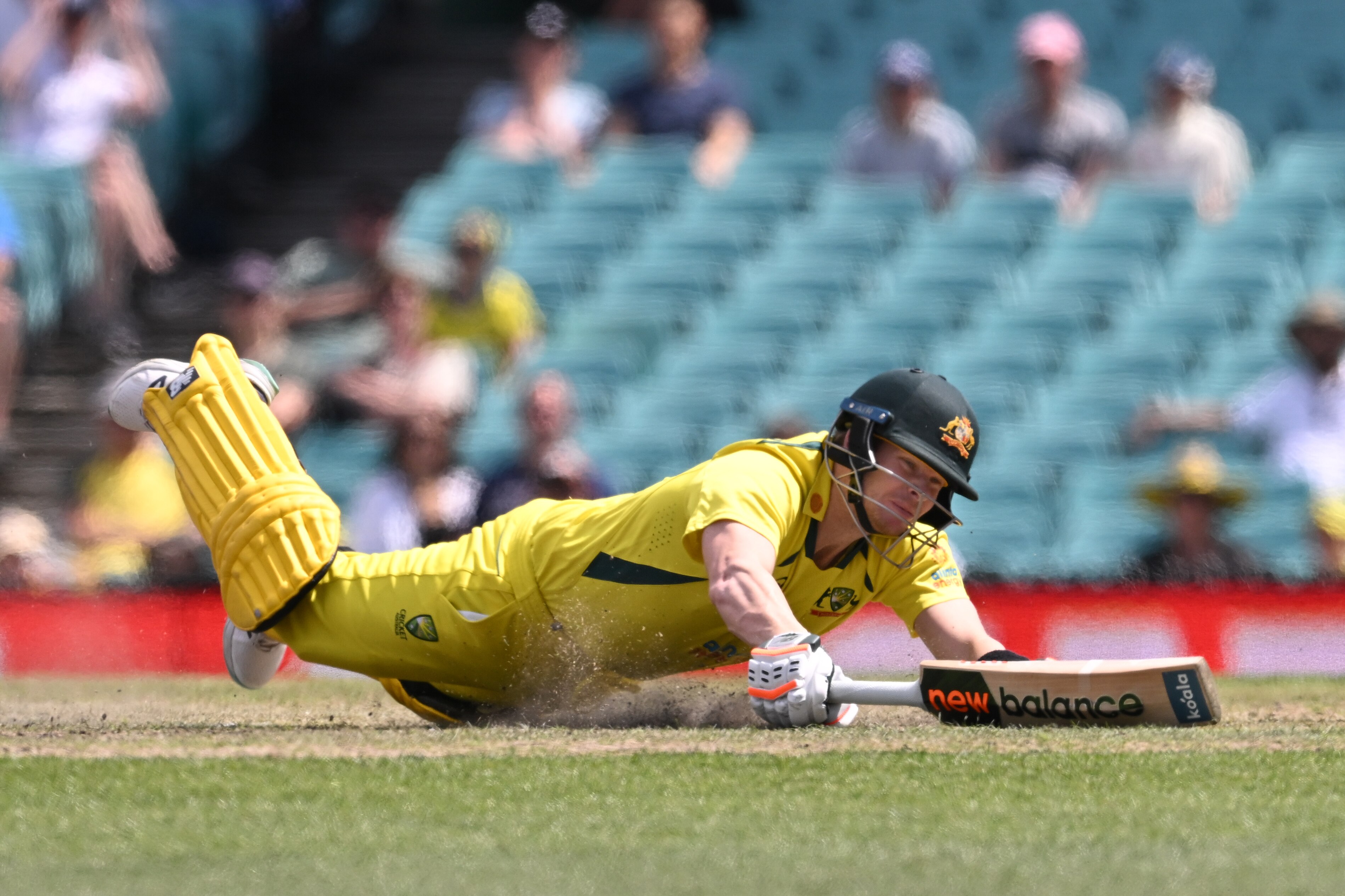 An Australian male batter slides on the ground with his bat during ODI against England.