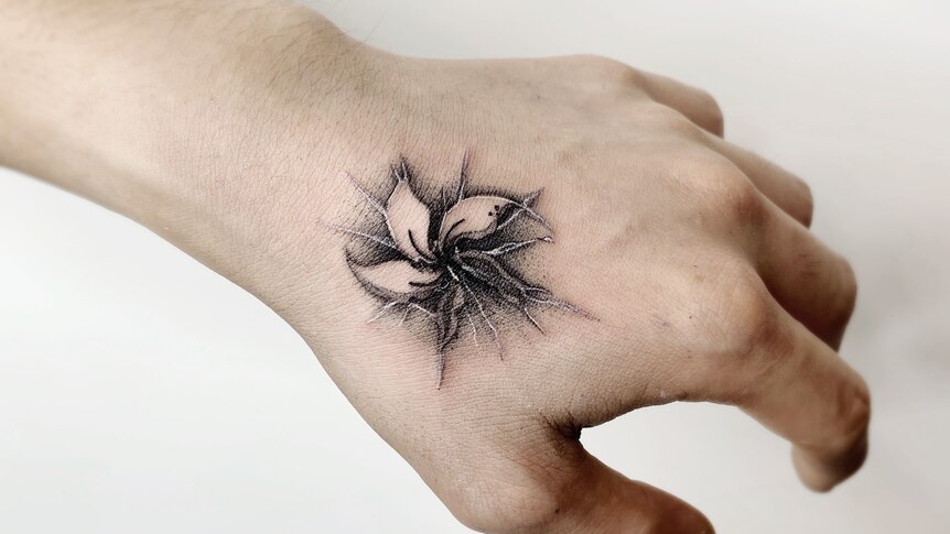 A broken flower tattooed on some one's left hand