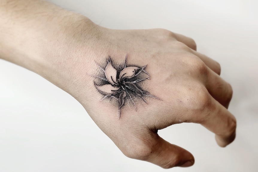 A broken flower tattooed on some one's left hand