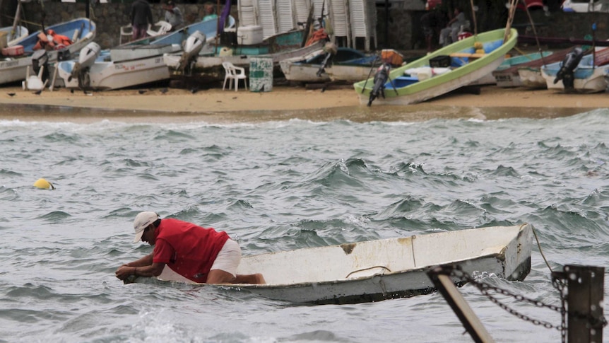 A fisherman checks his boat in Acapulco, Mexico before hurricane Patricia