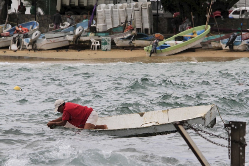 A fisherman checks his boat in Acapulco, Mexico before hurricane Patricia