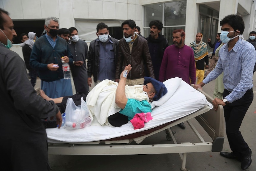 A patient is transferred on a hospital bed  after angry lawyers attack on a hospital in Lahore, Pakistan.