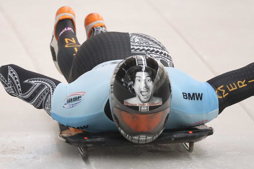 Nathan Crumpton on his sled looking forward as he races down the ice.