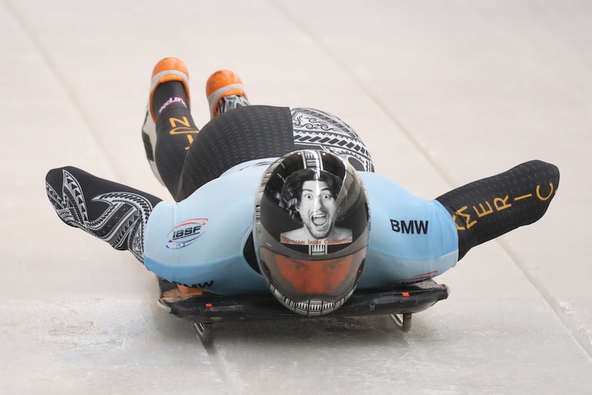 Nathan Crumpton on his sled looking forward as he races down the ice.