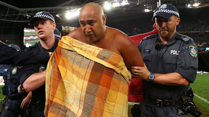 A streaker is taken from the field by police