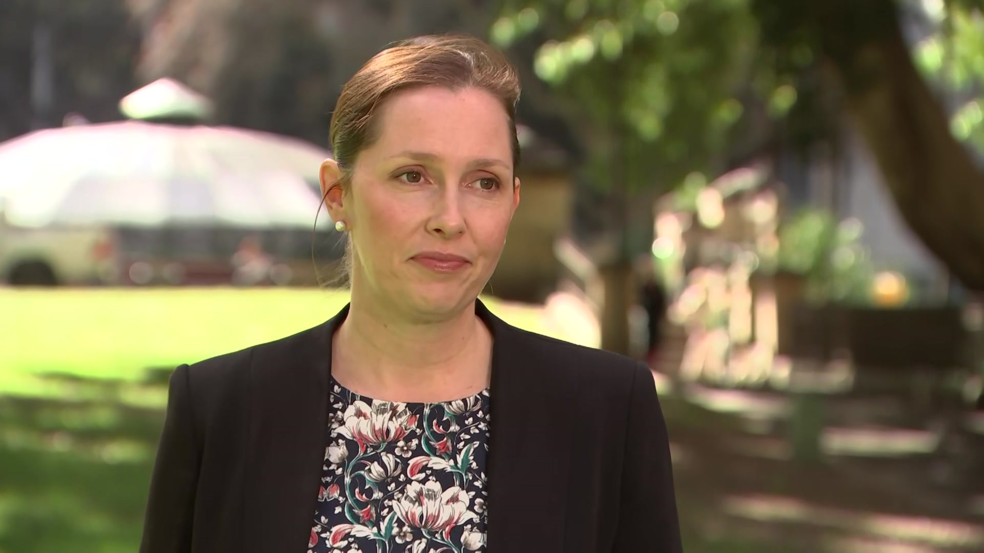 An older woman wearing a floral top and a black blazer