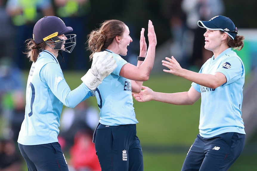 Three England players celebrate a wicket against South Africa in the Women's Cricket World Cup.