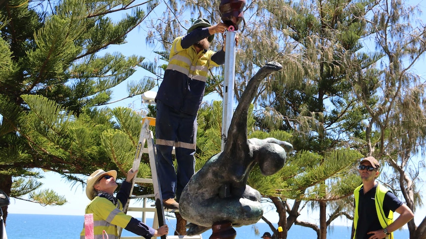 Toby Bell's 700 sculpture "The Cosmic Blacksmith" being erected at Cottesloe, with trees and the ocean in the background.