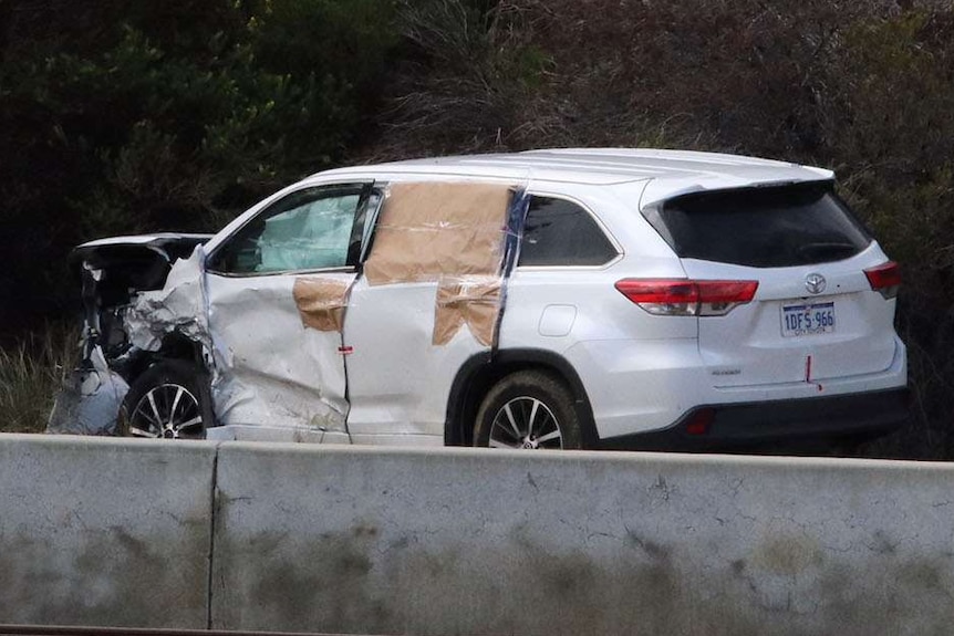 The car's front is completely crumpled. Its windows are covered with brown paper so you can't see the interior.