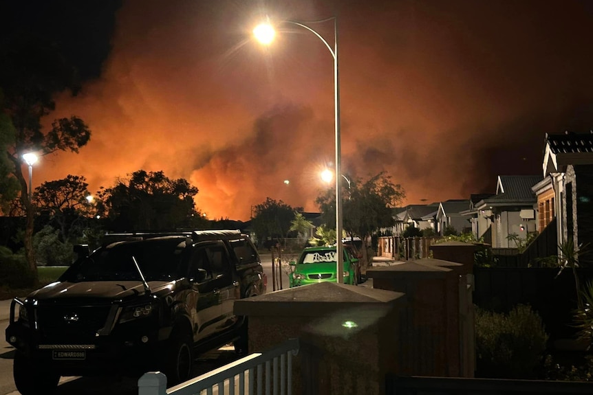Orange smoke billows over a residential area