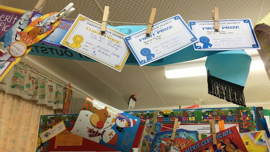 Awards hang from a string from the roof of the classroom.