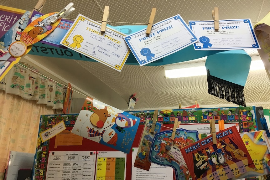 Awards hang from a string from the roof of the classroom.