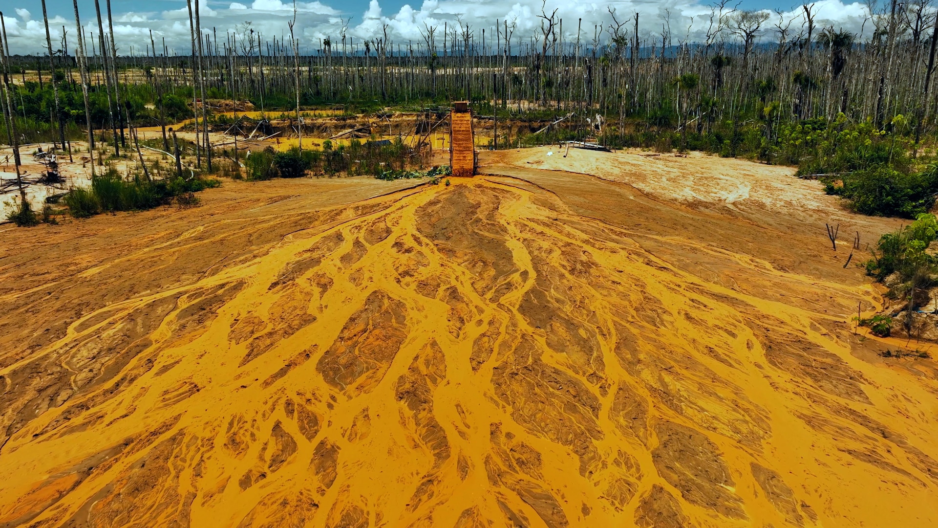Yellow sand and water run downa hill.
