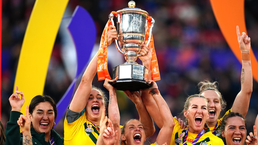 Jillaroos captains Kezie Apps, Sam Bremner and Ali Birginshaw lift the Rugby League World Cup trophy.