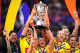 Jillaroos captains Kezie Apps, Sam Bremner and Ali Birginshaw lift the Rugby League World Cup trophy.