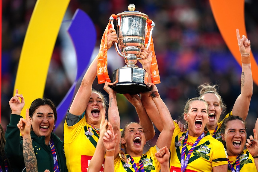 Jillaroos captains Kezie Apps, Sam Bremner and Ali Birginshaw lift the Rugby League World Cup trophy.