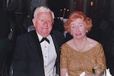An elderly man and woman pictured in black tie and formal gown