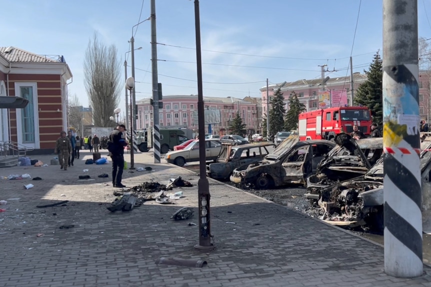 Damaged cars and debris are seen after a missile strike on a railway station.