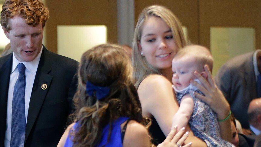 Saoirse Kennedy Hill holds a baby while another girl chats to her