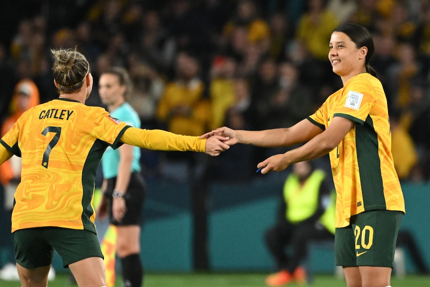 Steph Catley hands the Matildas' captain's armband to Sam Kerr during Australia's 2-0 win over Denmark in the Women's World Cup.