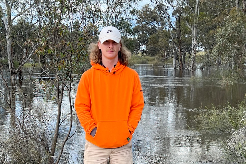 Dale stands with a flooded river visible behind him