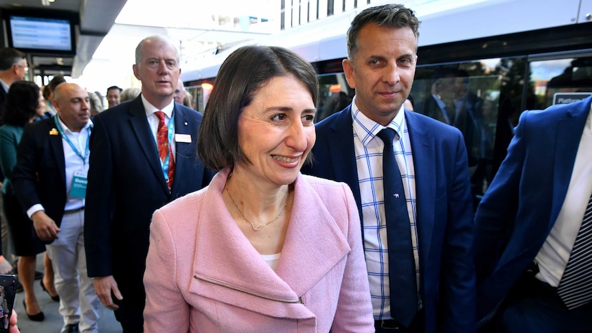 The premier smiling with a train in the background