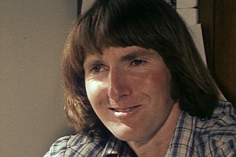 A man with brown hair smiling at the camera.