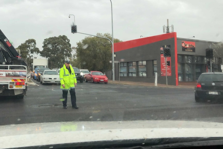 A police officer directs traffic during a blackout.