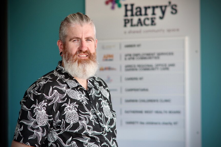 a man with a white/ginger beard wearing a printed shirt