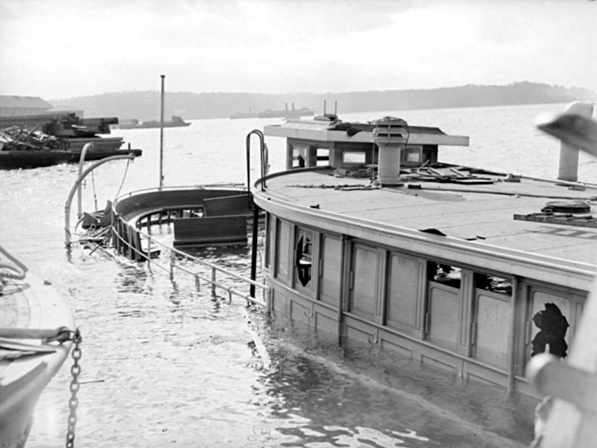 The wreck of HMAS Kuttabul sits half submerged in the waters of Sydney Harbour next to the dock at Gardens Point.