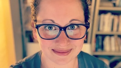 Alissa Wilkinson wearing glasses, bookcase in background