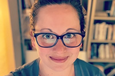 Alissa Wilkinson wearing glasses, bookcase in background