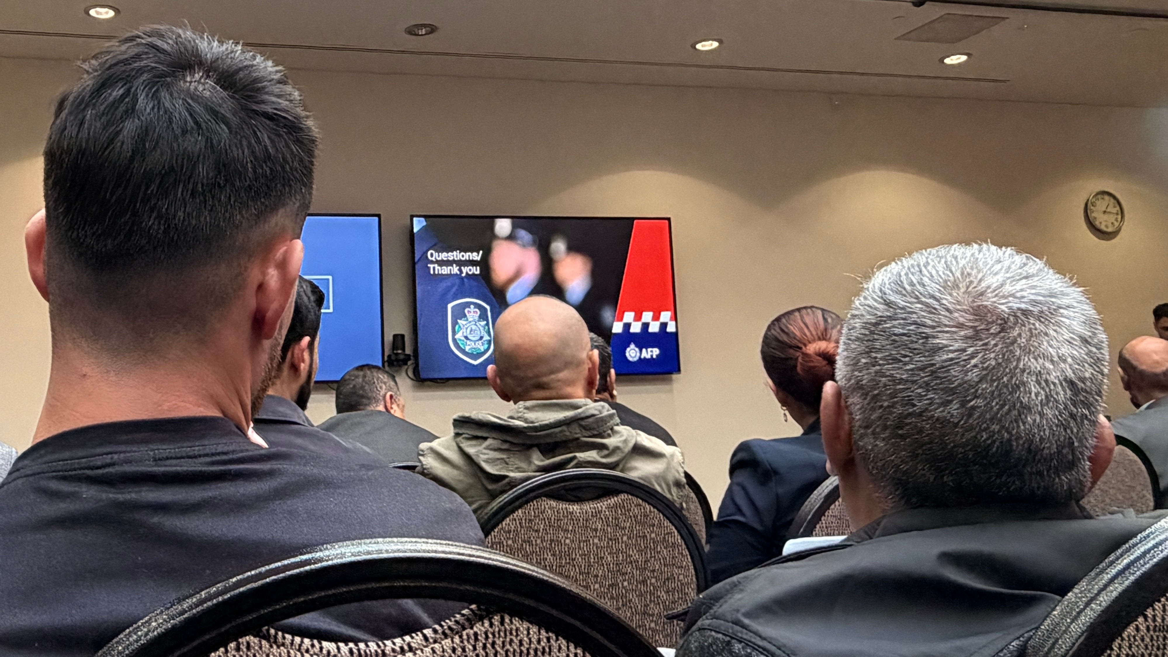 Back of people's heads looking at a screen with AFP branding and informaiton